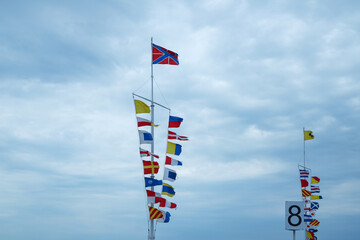 Nautical flags on the pier against the sky