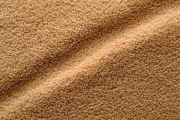 Close-up of beige, textured fabric with diagonal folds.