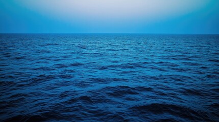 Obraz premium Serene ocean view under a vast blue sky. The deep blue water gently undulates, creating a calming and peaceful atmosphere.