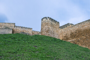 Obraz premium The walls of the ancient fortress are made of large stone blocks. View of the ancient Persian citadel. Ancient defensive structures. The high walls of the fortress in the Caucasus.