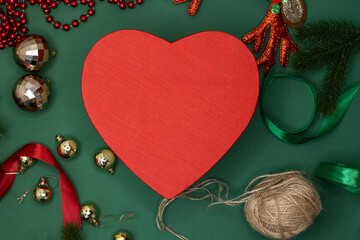 Red heart on Christmas background with balls ribbons. Concept: Christmas gift December. Elegant red Christmas card. Winter December holiday theme. Happy New Year