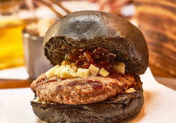 Black  hamburger close up. Fast food. Side view