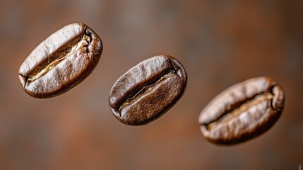 Fototapeta premium Three coffee beans defy gravity, suspended in mid-air with dazzling clarity. The rich, dark texture shines against a soft, blurred background, inviting a closer look at their unique form