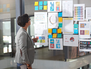 Business woman, documents and glass board with statistics for company growth, strategy or planning...