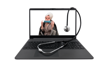 Laptop with a medical stethoscope on a transparent background. On the laptop screen - a girl with cold symptoms puts a protective medical mask on her face