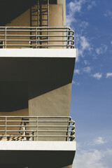 Modern building with multiple levels and clear blue sky with some clouds