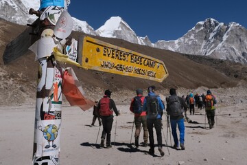Direction sign to Everest Base Camp in Gorakshep village. Silhouettes of hikking people on background. Sagarmatha National Park, Khumbu valley, Nepal © Iwona