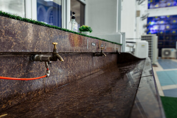 The faucet at the mosque , offering water for the sacred act of cleansing before prayer