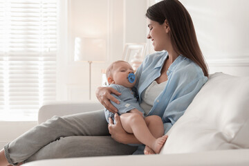 Obraz premium Mother with her sleeping baby on sofa at home