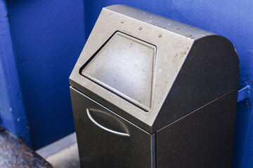 Metal trash bin on a ship. Waste disposal background. Maintaining cleanliness during ferry travel....