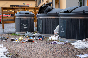 Overflowing garbage containers with scattered waste, including food and trash bags, concept of...