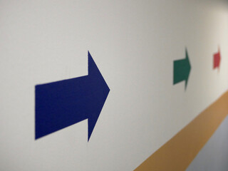 blue green and yellow arrow painted on a wall showing directions