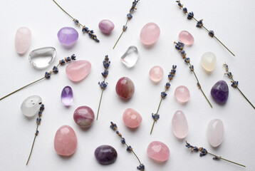 Natural crystals and gemstones minerals amethyst and rose quartz on a background with lavender branches. Healing crystals.