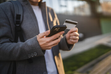 Close up of adult man shop online on mobile phone with credit card