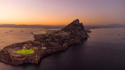 Aerial view of Gibraltar at sunset. Street lights on. Europa Sports Complex Stadium with night light on. Famous travel destination. Bay of Gibraltar. City of Gibraltar and La Linea, in background.