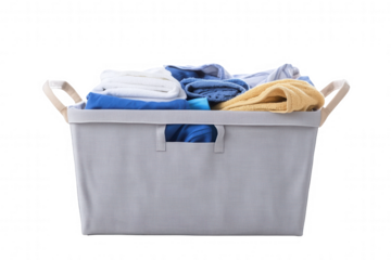A laundry basket is filled with an assortment of clean towels in different colors including blue, yellow, and white. The basket is textured and has a simple design, highlighting the towels arranged ne
