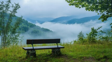 Obraz premium A scenic overlook with a bench facing foggy mountain landscapes, ideal for peaceful contemplation.