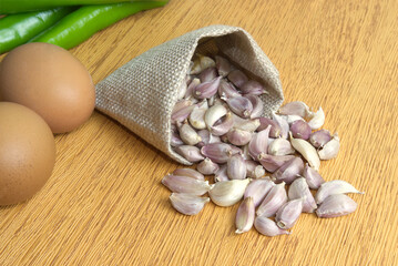 Small cloves of garlic in a sack Put it on the wooden table in the kitchen.