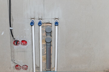 Installing electrical wiring on a wall. Installing water pipes in a building. Building under...