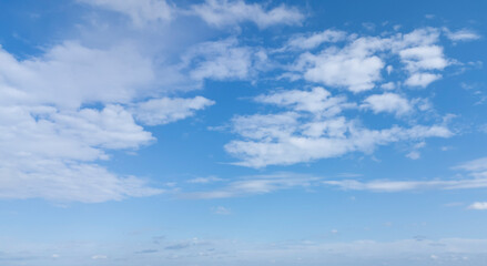 Obraz premium A vast blue sky with fluffy white clouds, creating a serene and peaceful atmosphere. Ideal for backgrounds or nature-related themes.