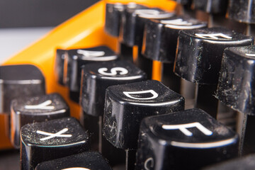 Close-Up View of Black Typewriter Keys with Orange Detail