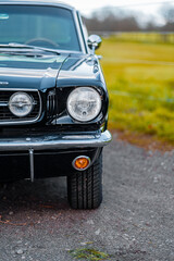 Front View of a Classic Black Car with Shiny Vintage Headlights
