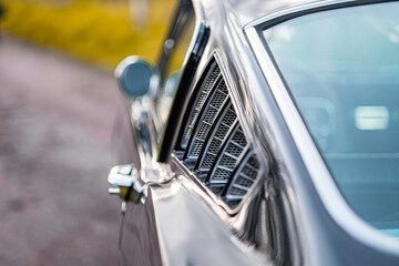 Close-Up of a Vintage Car Window Detail Featuring Chrome Accents and a Unique Retro Design