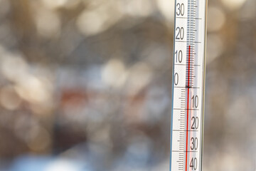 Outdoor thermometer showing warm temperature of 18 degrees Celsius