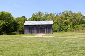 The old wood barn in the country on a sunny day.