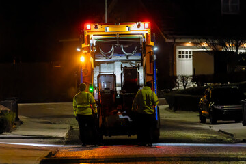 Recycling Garbage Truck and Men Collecting Wheelie Bins at Night on Residential Street