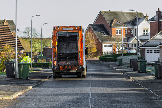 Recycling Garbage Truck and Men Collecting Wheelie Bins on Residential Street