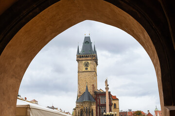 Astronomical clock tower framed in a stone arch of the buildings on the square, Prague.