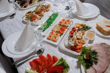A table with a variety of desserts, including cakes and pastries. The desserts are arranged in a...