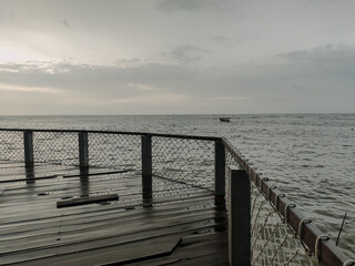 Beach view with cloudy weather on the edge of the pier. Bad weather concept at sea
