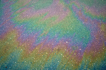 Gasoline or oil spill creating rainbow colors on wet asphalt.