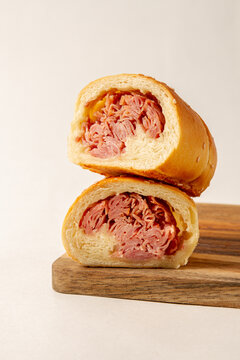 Cachito of ham. bread of ham, over a wooden plate on white background