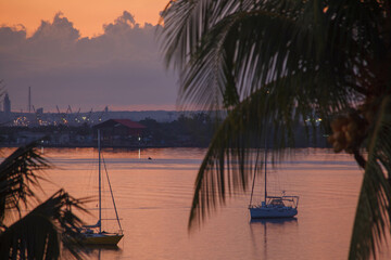 Sailing boat on a beautiful pink sunset with amazing sky at Punta Gorda, Cienfuegos, Cuba