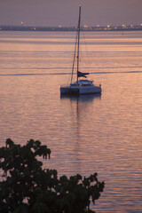 Sailing boat on a beautiful pink sunset with amazing sky at Punta Gorda, Cienfuegos, Cuba