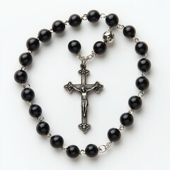 Obraz premium A black rosary with a silver crucifix, symbolizing faith and devotion in prayer.