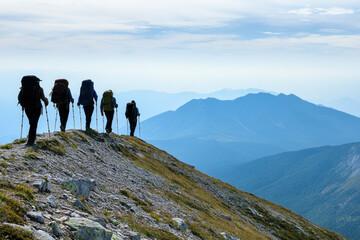 Obraz premium Group of hikers trekking on mountain ridge with scenic views