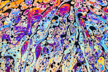 Real photograph of a colorful light interference on a soap bubble surface with random swirls,...