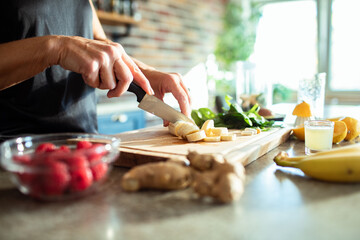 Senior woman making healthy organic smoothie in modern kitchen