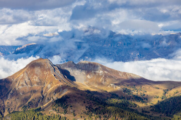 Above the clouds mountain landscape in the Dolomiti Alps, Italy. Rocky prominent towering peaks high up above the clouds. Cloudscape in the Dolomites
