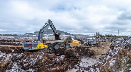 Peat excavation with an excavator and dump trucks, in winter