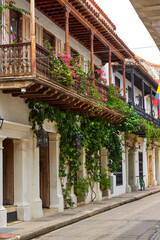 Fototapeta premium Timeless charm hangs from every balcony in Cartagena de Indias.These weathered railings and cascading bougainvilleas tell stories of romance, history, and the magic of a city frozen in time.