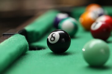 Many colorful billiard balls on green table indoors, closeup