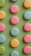 Obraz premium Colorful macarons arranged on a green background showcasing various pastel shades