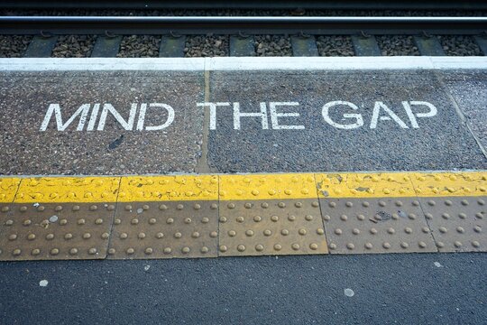 Mind The Gap with a yellow stripe painted onto a platform, London, England. 