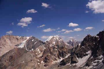 mountain landscape on a sunny day. Gray rocks and mountains covered with snow without vegetation