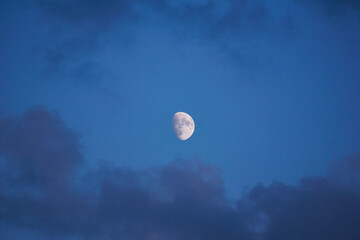 the moon with craters in the sky with clouds